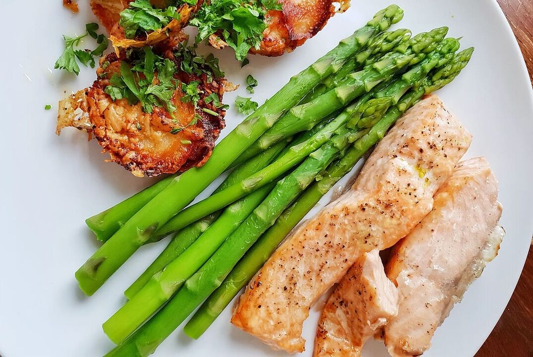 Pesce al forno con asparagi nel menù dietetico a basso contenuto di carboidrati